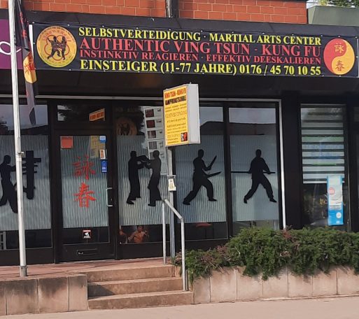 Martial Arts Zentrum mit Silhouetten von Kämpfern und rotem Schild.