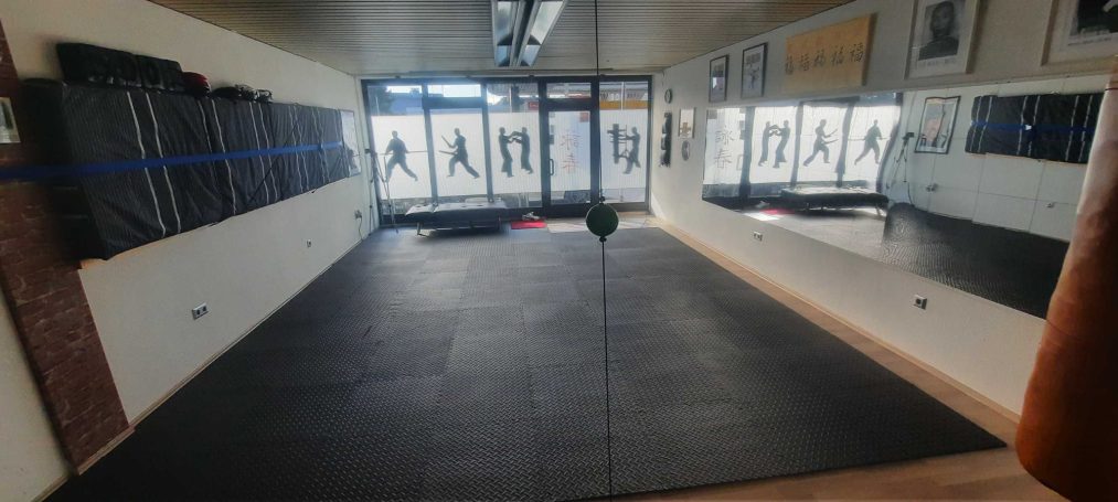 Kampfkunststudio mit Spiegeln und einem freien Trainingsbereich.