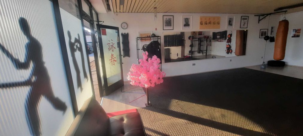 Innenraum eines Fitnessstudios mit einer pinken Dekoration und verschiedenen Sportgeräten.