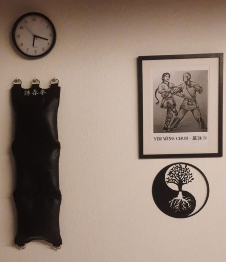 Wanduhr, ein Bild von Tänzern und ein Baum-Symbol an der Wand.